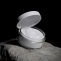Open jar of night cream on a stone