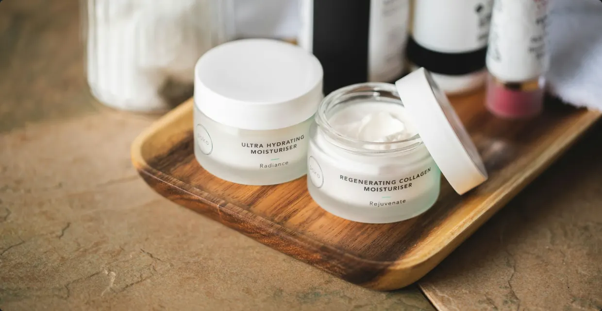 Jars of face cream on a wooden tray