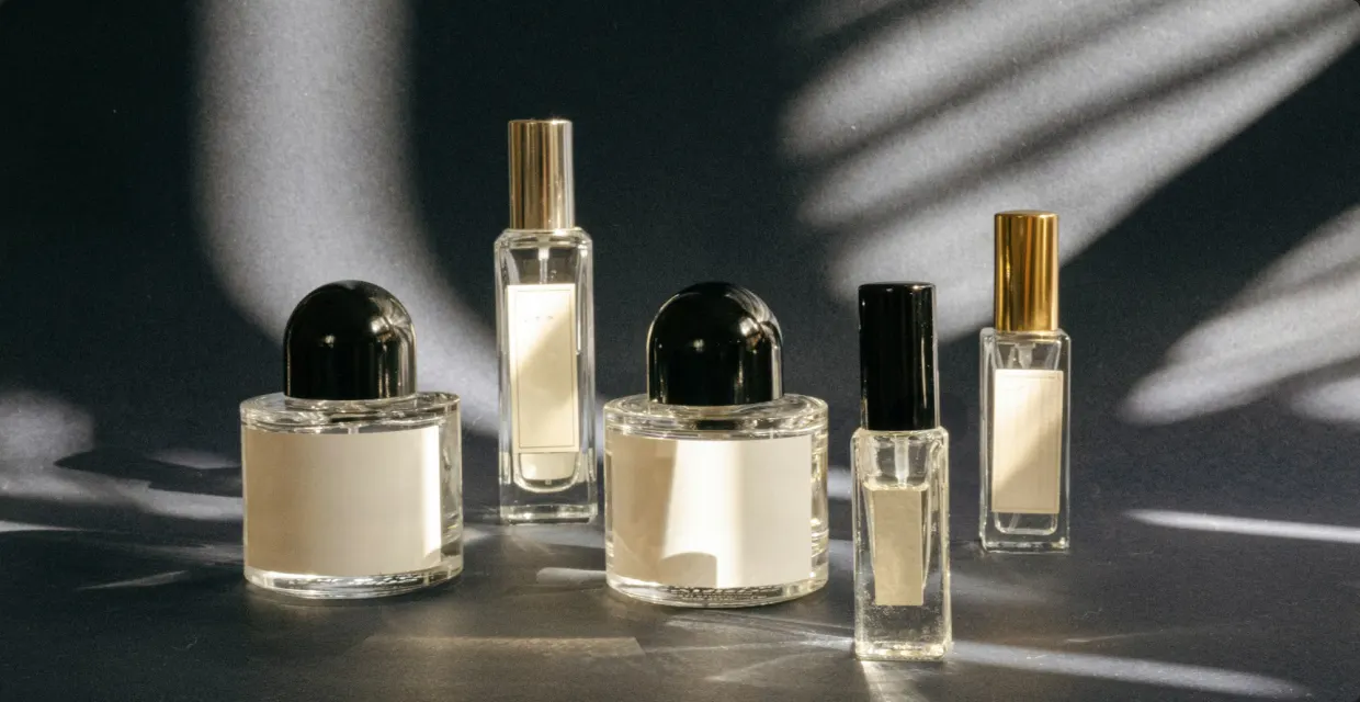 Perfume bottles of different sizes in dappled light