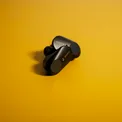 Black open-ear headphones on a yellow background