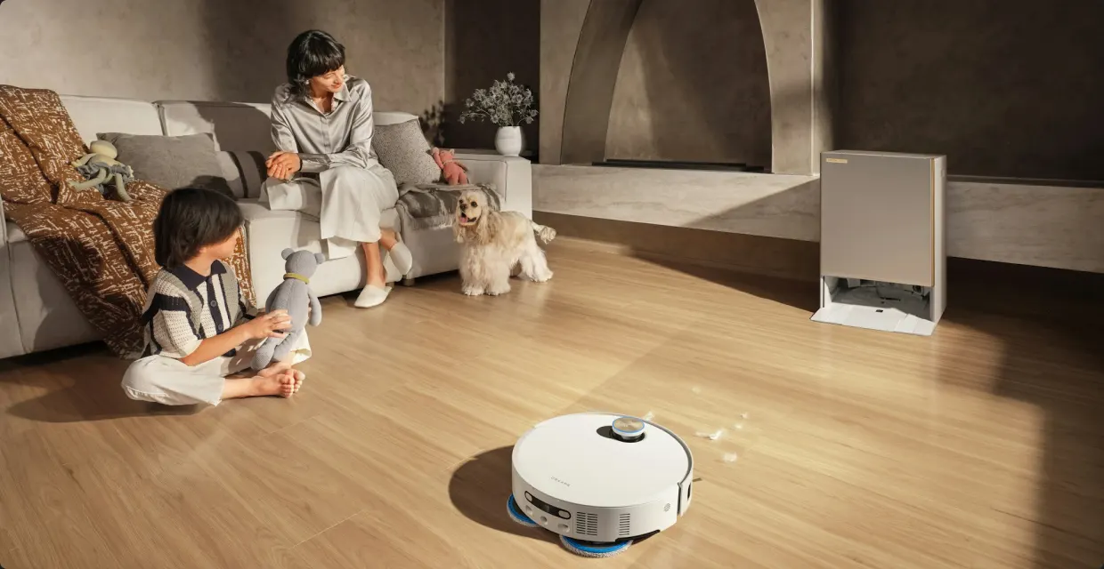 Robot vacuum cleaning a living room floor while a family relaxes