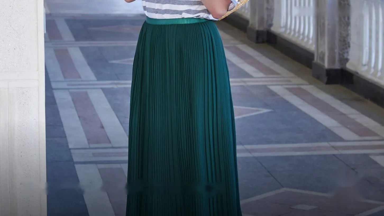 Long pleated green skirt on a stone terrace