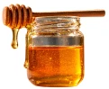 Jar of honey with a dipper