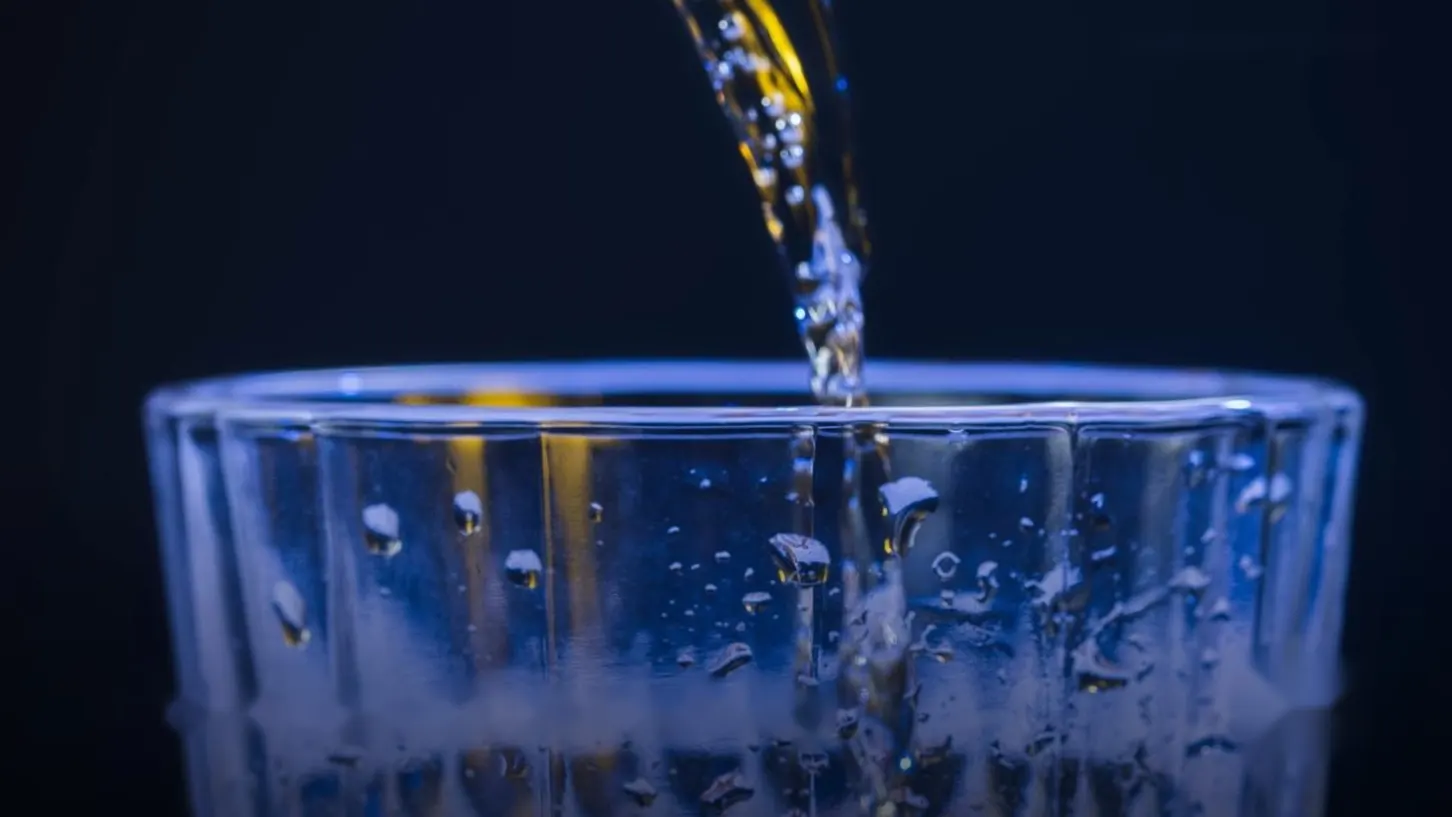 Sparkling water poured into a ribbed blue glass
