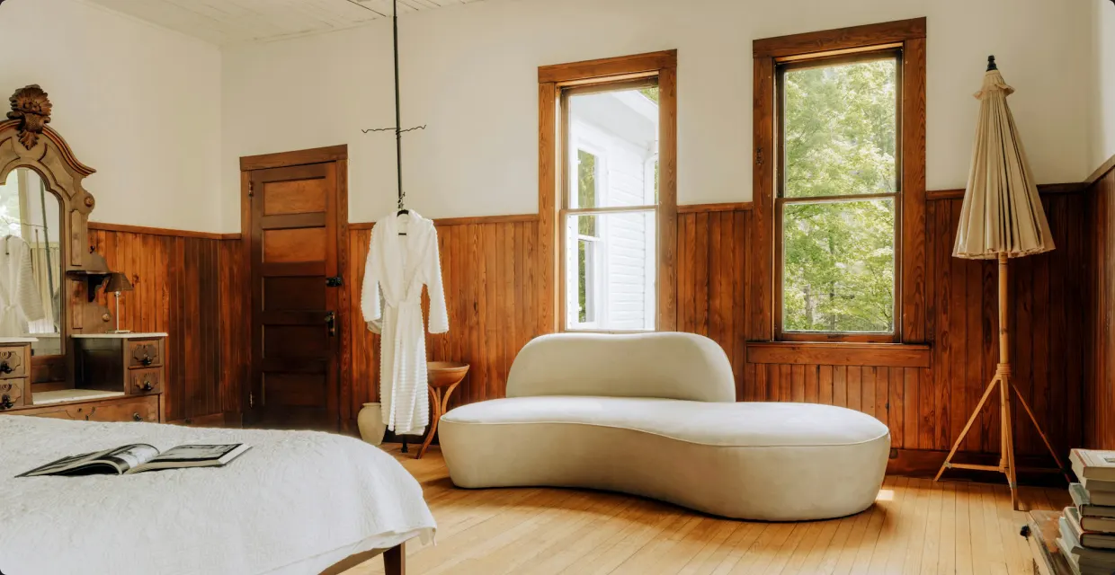 Curved cream sofa in a room with wooden walls