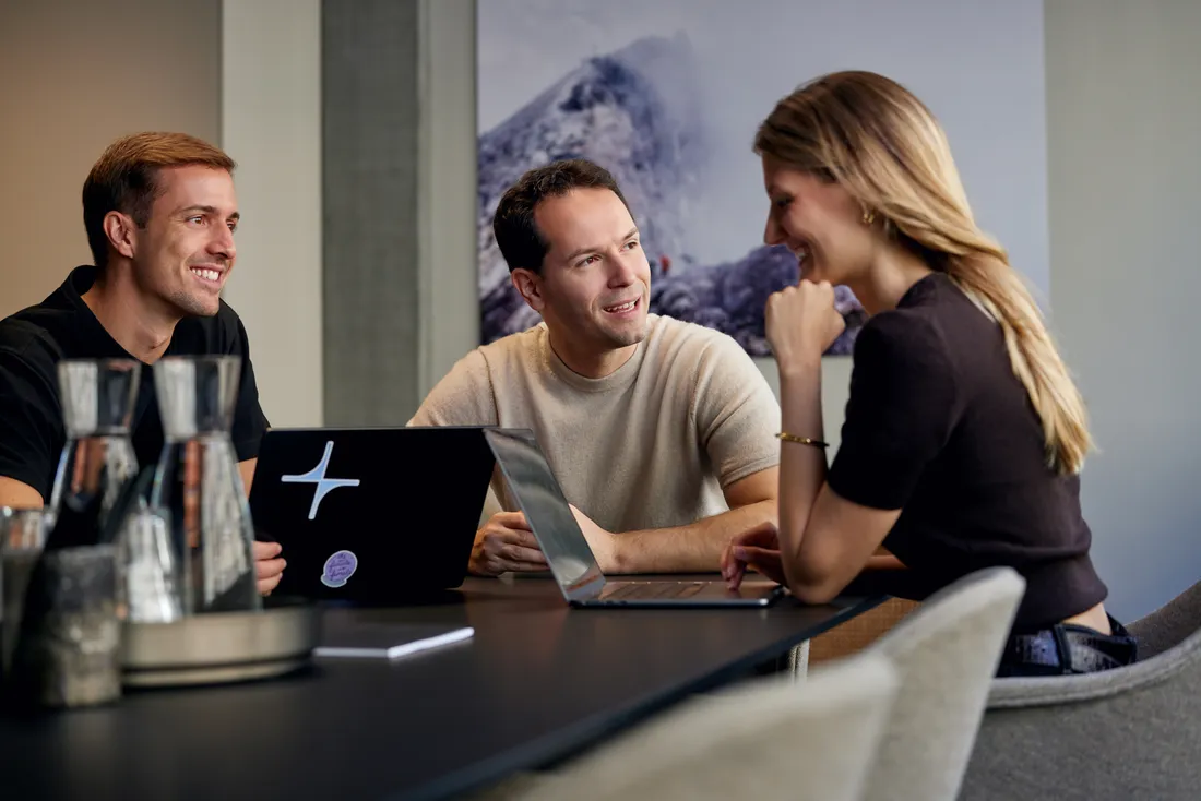 Zenline team members talking at a desk in the Zurich office