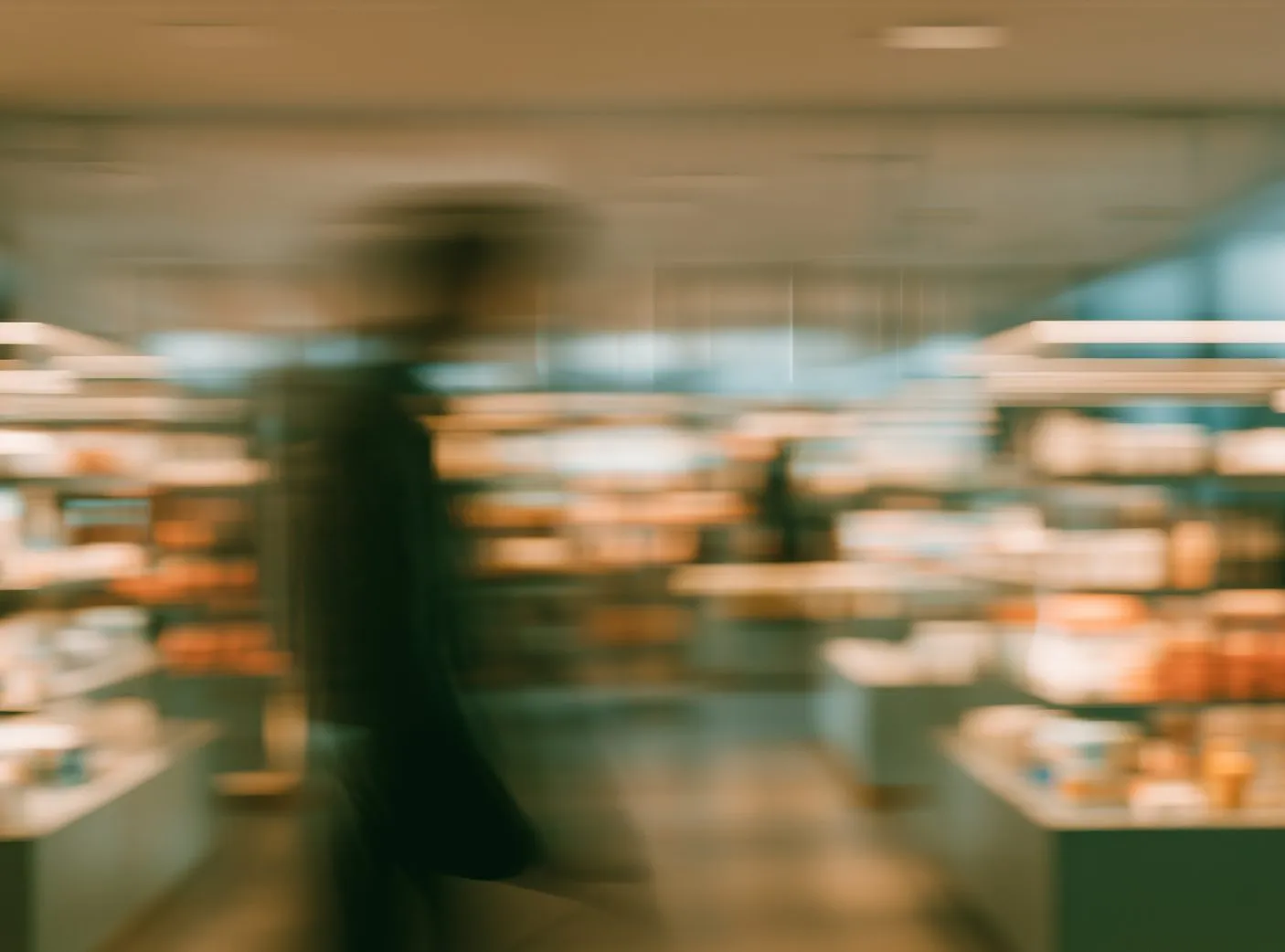 Shopper walking past store shelves, in motion blur