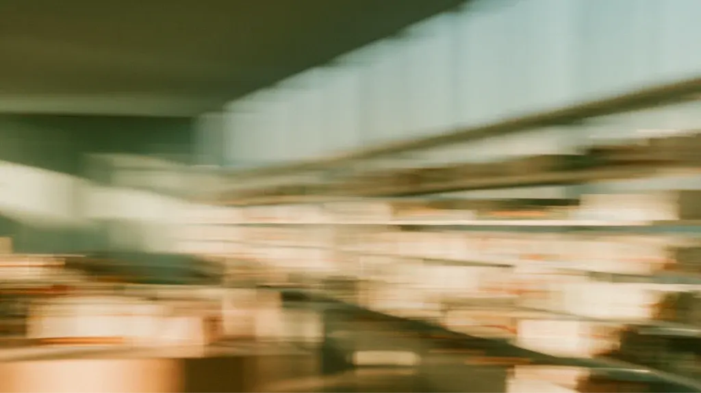 Shoppers in a bright store aisle, softly blurred